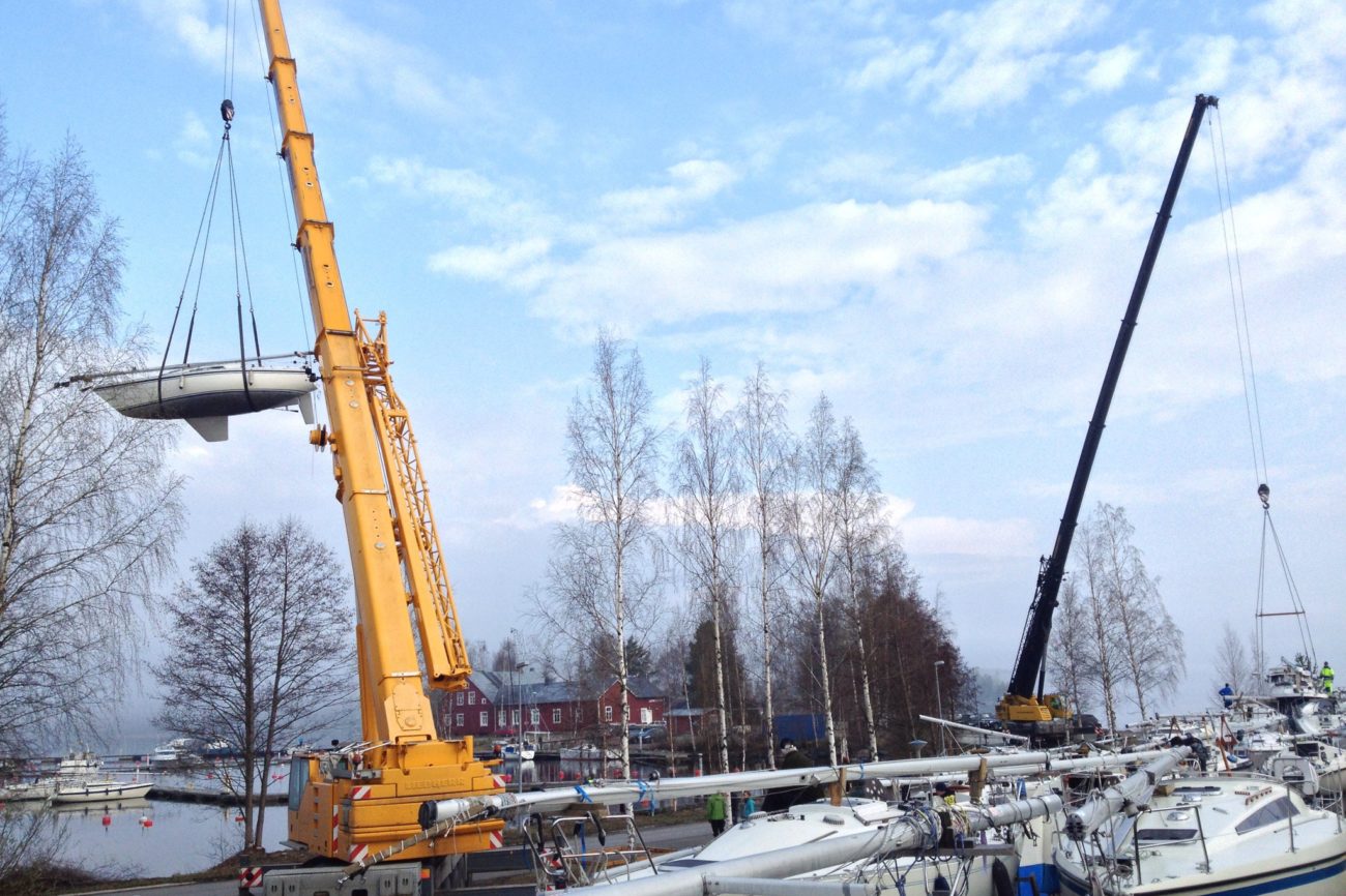 Nosturi laskemassa purjevenettä veteen Juurikkasaaren satamassa