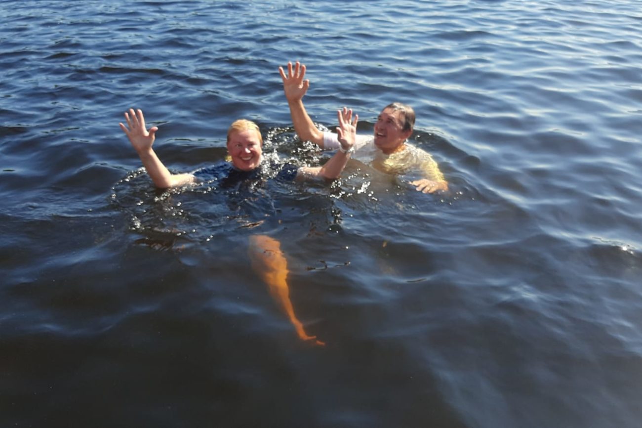 Kaksi ihmistä uimasillaan järvessä